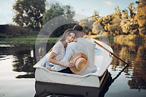 Love couple in boat on quiet lake, romantic date
