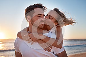 Love, couple and cheek kiss at beach on date, vacation or summer trip. Sunset, affection or romance of man and woman