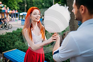 Love couple with cotton candy in summer park