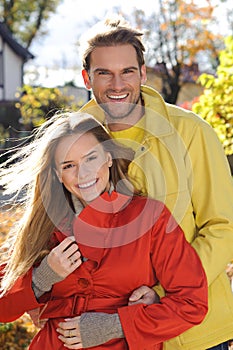 Love couple embracing and loving in season - autumn park, coloursfull leaves, pregnant woman, smiling healthy couple, sunny day