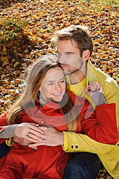 Love couple embracing and loving in season - autumn park, coloursfull leaves, pregnant woman, smiling healthy couple, sunny day