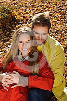 Love couple embracing and loving in season - autumn park, coloursfull leaves, pregnant woman, smiling healthy couple, sunny day