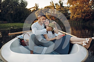 Love couple hugs in a boat on quiet lake