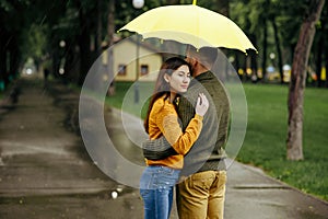 Love couple hugs in park, summer rainy day