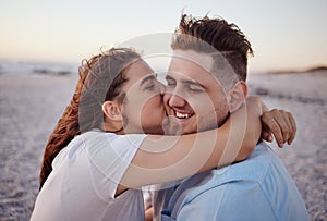 Love, couple and kiss on beach happy to celebrate relationship with sunset being relax, smile and on holiday. Romance