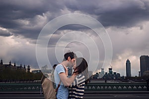 Love, couple and kiss on city bridge or outdoors in town on vacation, trip or holiday, Cloudy day, romance and affection