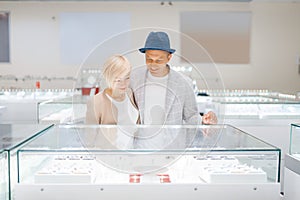 Love couple looking on jewels in jewelry store