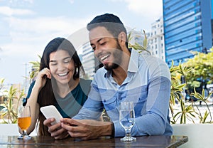 Love couple looking at phone at restaurant