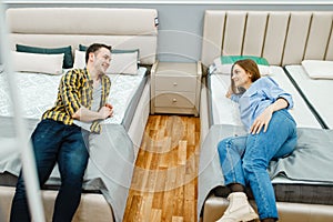 Love couple lying in bed, furniture store showroom