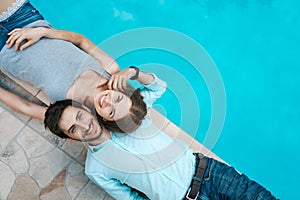 Love couple lying near swimming pool