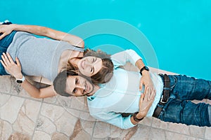 Love couple lying near swimming pool