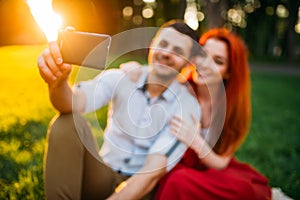 Love couple makes selfie in summer park on sunset