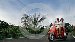 Love couple on red motorbike in white clothes to go on forest road trail trip. Two caucasian tourist woman man drive on