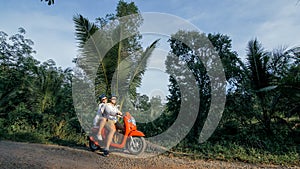 Love couple on red motorbike in white clothes to go on forest road trail trip. Two caucasian tourist woman man drive on