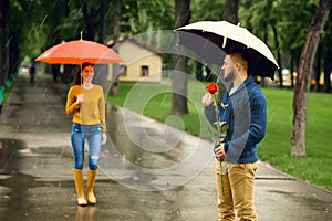 Love couple with umbrellas, date, rainy day