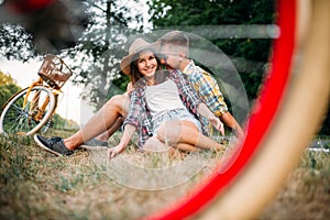 Love couple with vintage bikes sitting on grass