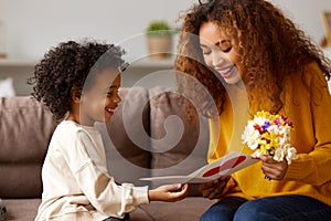 Young mixed race woman getting congratulations from son on Mothers day