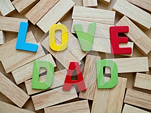 Love dad. Happy Father& x27;s Day celebrations. Love dad word from colorful of wood on wooden block in background
