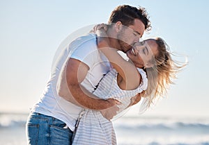 Love, dating and couple kiss at beach enjoying summer holiday, vacation and honeymoon by the sea. Travel, romance and