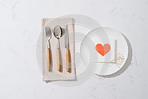 Love dinner setting fork and spoon tie with red ribbon on plate