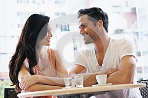 Love, discussion and couple with coffee on date for romance or anniversary in cafeteria. Happy, bonding and young man