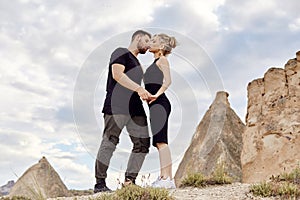 In love Eastern couple in mountains of Cappadocia hugs and kisses. Love and emotions loving couple vacationing in Turkey. Closeup