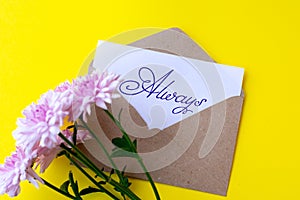 Love envelope and letter with written word always with pink chrysanthemum flowers on yellow bacground