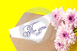 Love envelope and letter with written words for you with pink chrysanthemum flowers