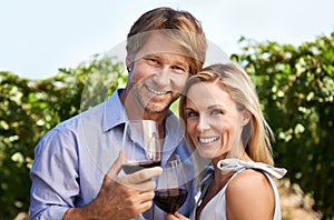 We love this estate. Portrait of a mature couple enjoying wine tasting in a vineyard.