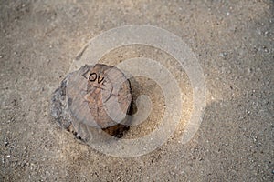 Love etched carved out on a small tree stump in sand pit