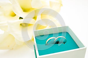 love, family, celebration, ceremony concept -wedding symbols two golden rings with callas white flowers