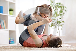 Love and family people concept - happy mom and child daughter having a fun at home photo