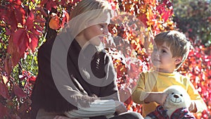 Love family. Happy mother and son outdoors. Mother and son playing in autumn park and having fun. Mother and children