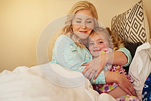 The love of a family. a mother bonding with her little daughter in bed at home.