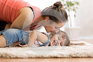 Love and family people concept - happy mom and child daughter having a fun at home