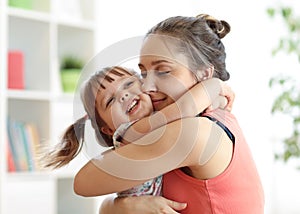 Love and family people concept - happy mother and child daughter hugging at home