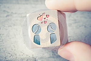 Love At First Sight For A Gay Men Couple With Flying Hearts Engraved On A Wooden Block Held By Two Fingers