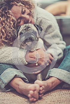 Love and friendship concept with happy defocused caucasian adult woman hug her lovely old dog pug - animal therapy and best friend