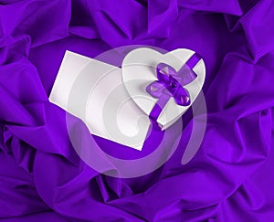 Love greeting card with heart on a purple fabric