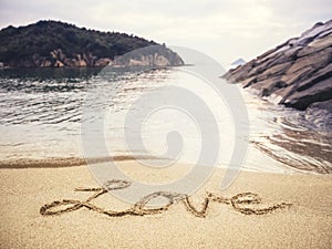 Love handwriting on Sand Beach Holiday background