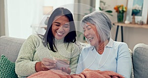 Love, happy and daughter with mother and pictures on the living room sofa, laughing and bonding. Happy, family and Asian