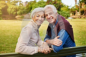 Love has no age. Portrait of a happy senior couple sitting on a park bench.