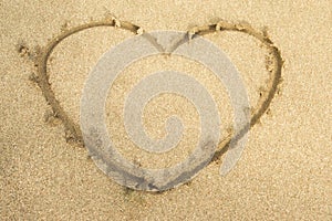 Love heart drawing on beach sand