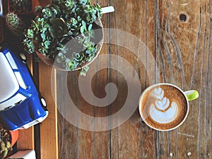 Love heart latte art coffee cup on the vintage wooden table with blue Ceramic car