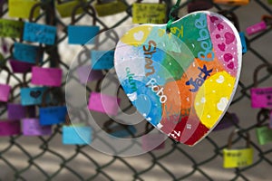 Love heart and love padlocks on a wire chain fence.