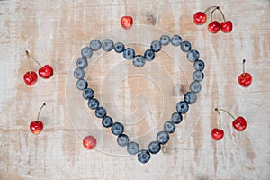 Love heart made of blueberries and widespread cherries
