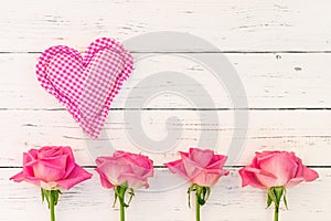 Love heart with pink roses on white wood background and copy space