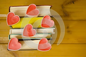 Love hearts on books on wooden background.Book lovers