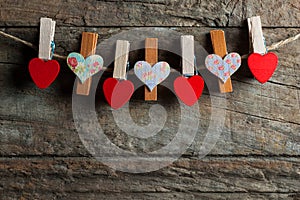Love Hearts clothespins or pegs on a rope on wooden rustic vintage background