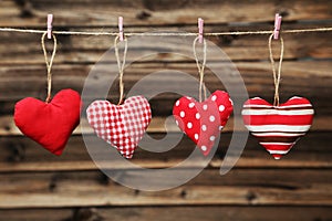 Love hearts hanging on rope on the brown wooden background